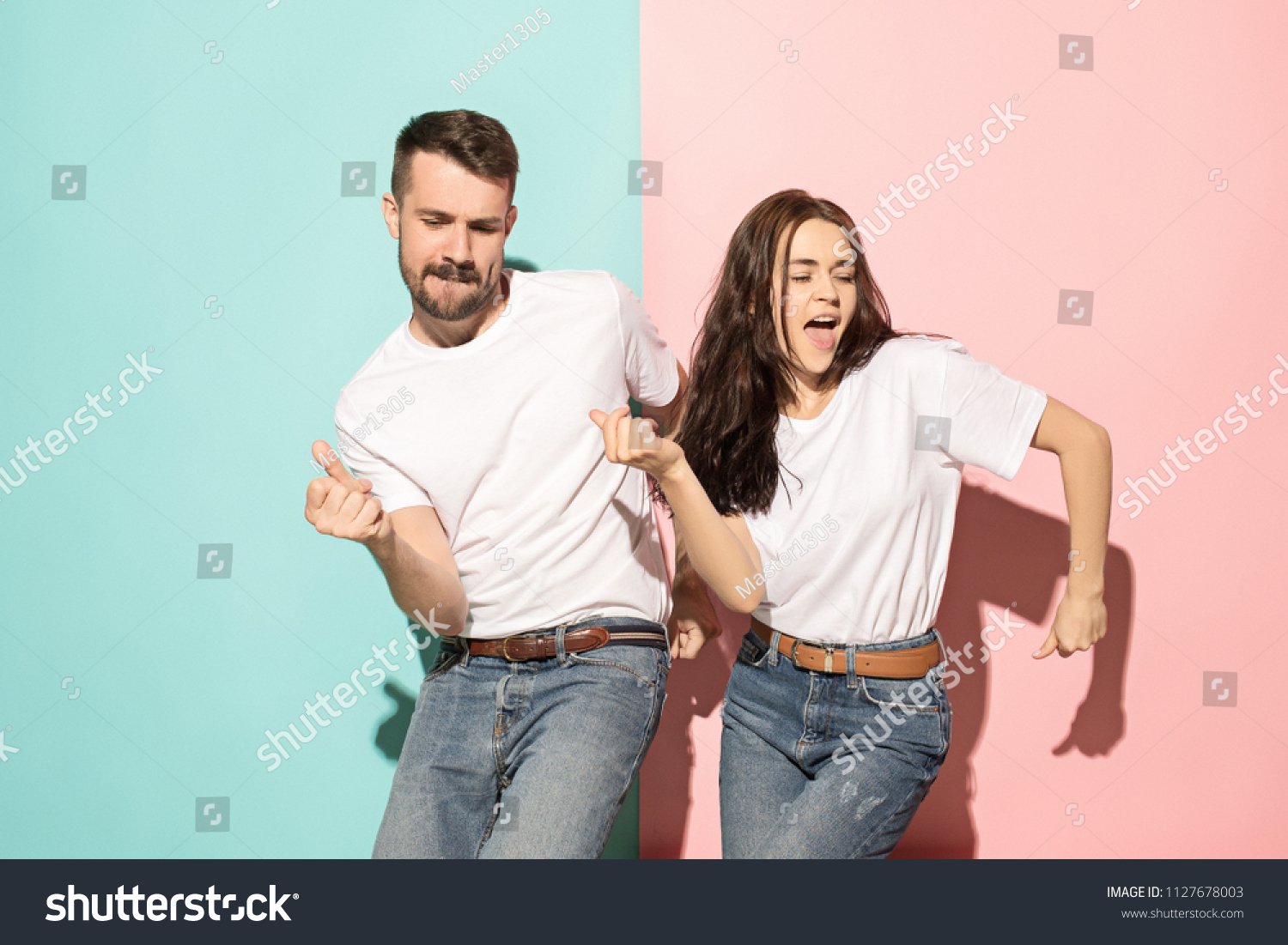 Ein paar junge lustige und glückliche Mann und Frau tanzen Hip Hop im Studio auf blauem und rosafarbenem, trendigem Hintergrund. Menschliche Emotionen, Jugend, Liebe und Lebensstil – Stockfoto