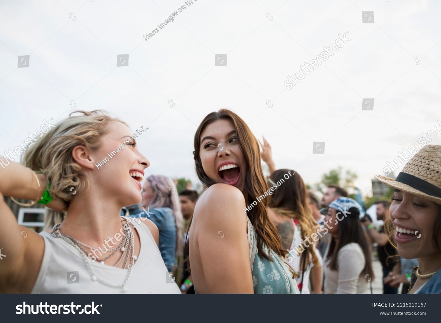 Begeisterte junge Frauen, die bei Sommermusikfestivals in Menschenmenge tanzen – Stockfoto