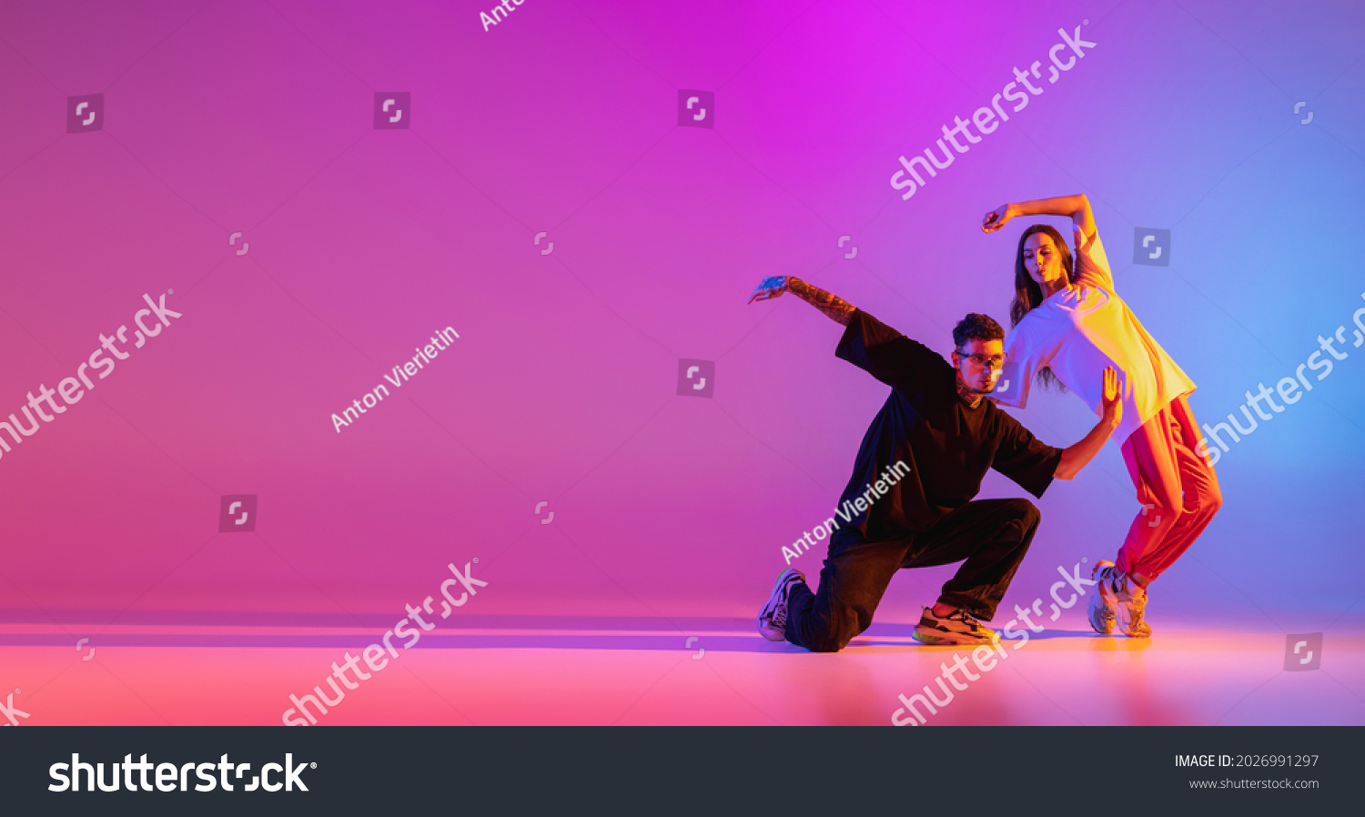 Flyer. Seltsame Körperbewegungen. Zwei junge Leute, Typ und Mädchen tanzen zeitgenössischer Tanz auf rosafarbenem Hintergrund in Neonlicht. Modernes Tanzkonzept – Stockfoto