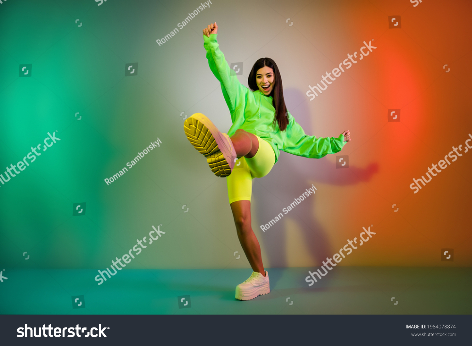 Volllange Körpergröße mit Blick auf ein ziemlich funky, fröhliches Mädchen, das gute Laune tanzt einzeln auf mehrfarbigem, lebendigem Neonhellhintergrund – Stockfoto
