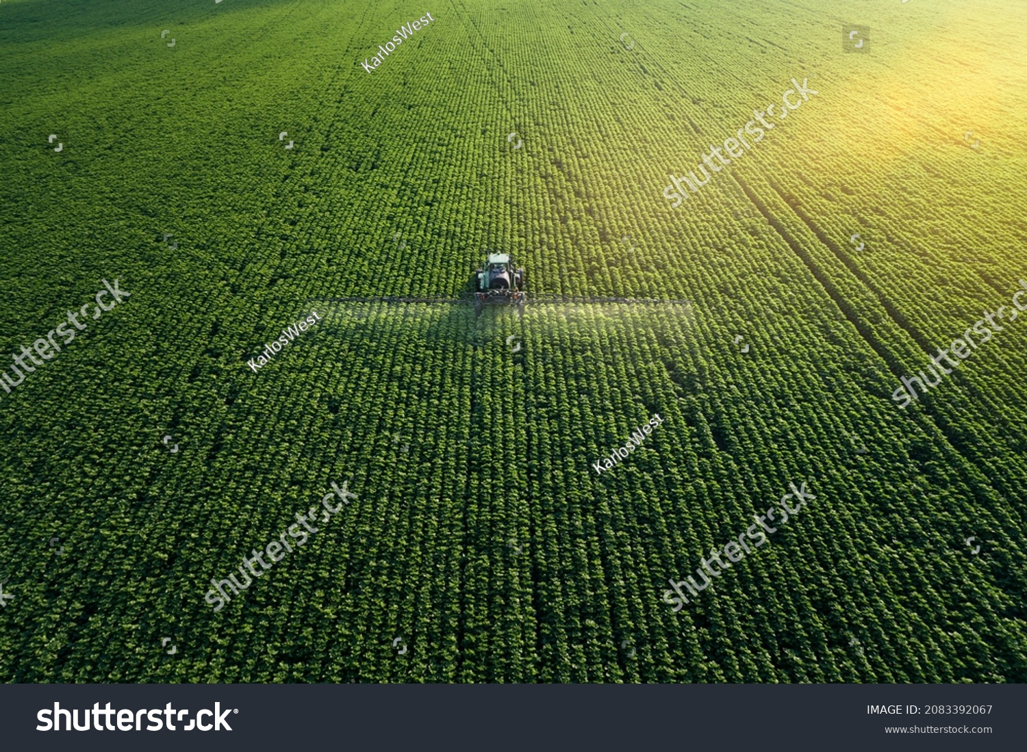 Sorge für die Kultur. Luftbild eines Traktors, der ein landwirtschaftlich genutztes Feld befruchtet. – Stockfoto
